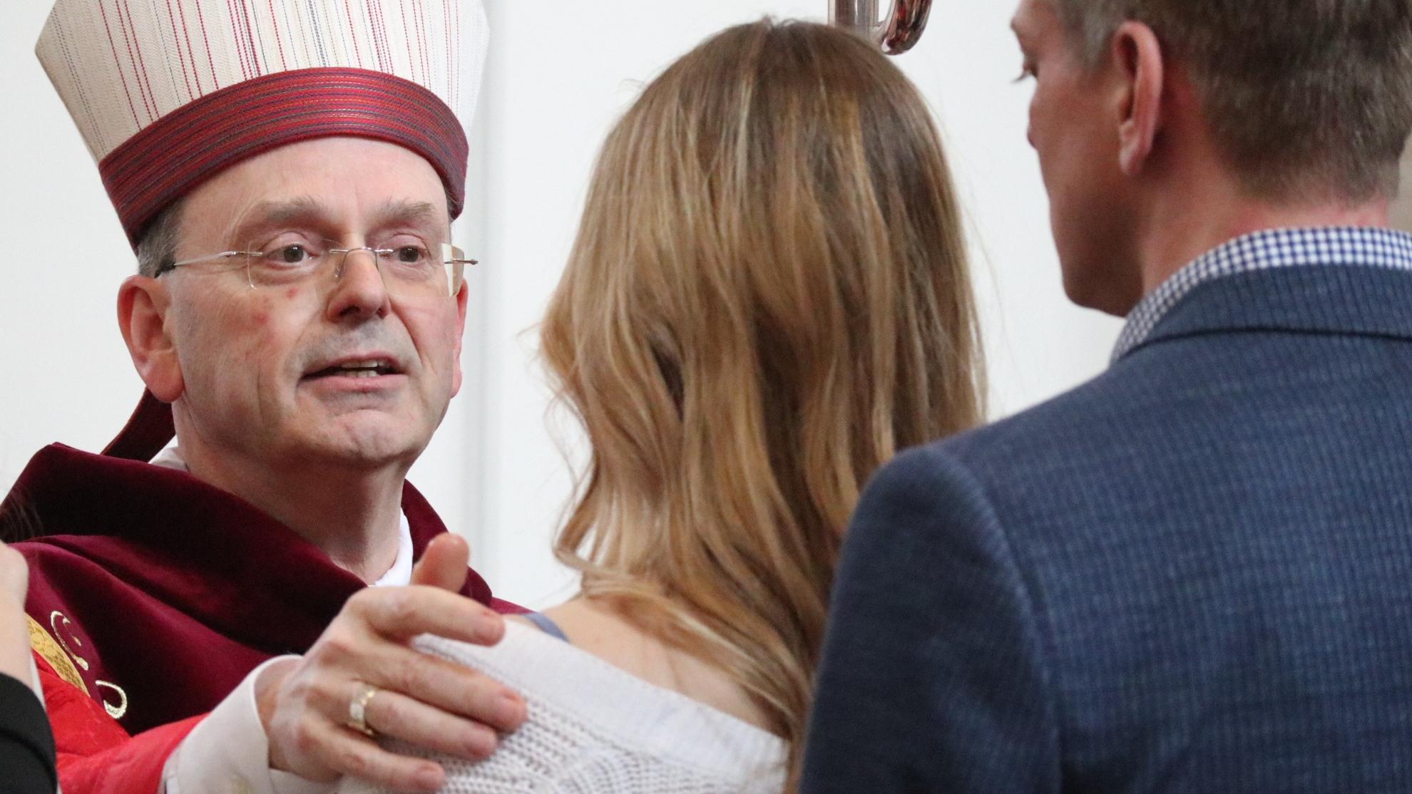 Weihbischof Robert Brahm firmt eine Jugendliche.